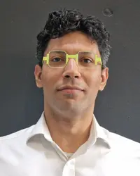 Ahmed Elghareeb, smiling, in green glasses and a white shirt